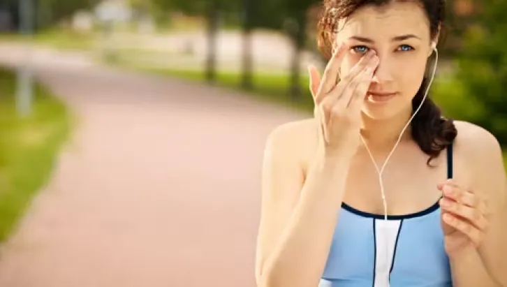 A-woman-touching-her-eye-while-exercising