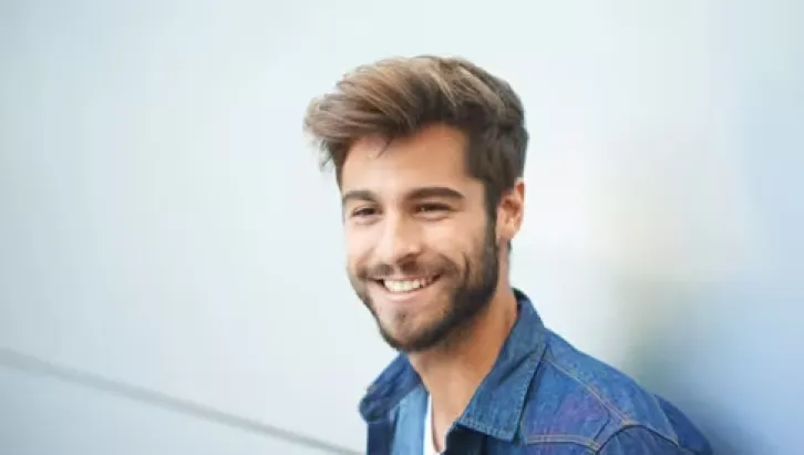 Smiling-bearded-young-man-in-blue-denim-button-down-shirt