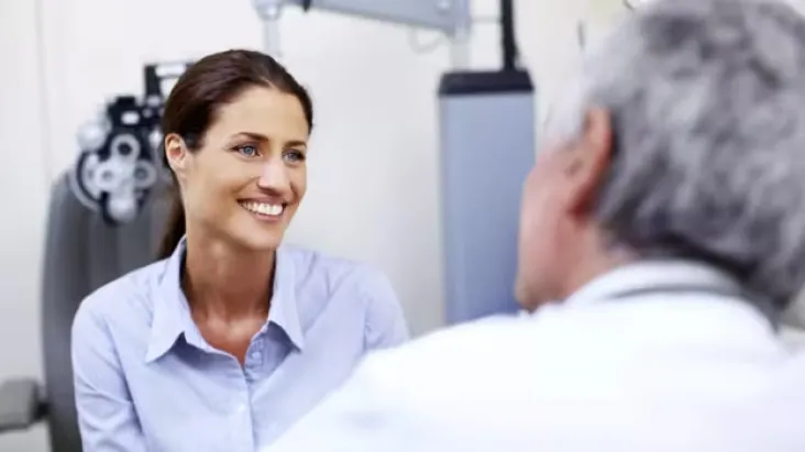 smiling-young-woman-being-attended-to-by-a-doctor